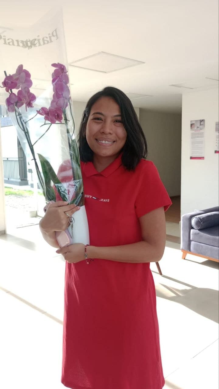 Cliente sonriente con Phalaenopsis fucsia